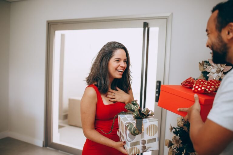 Woman smiling as she receives a wrapped gift, one of many thoughtful gift ideas for friends and family