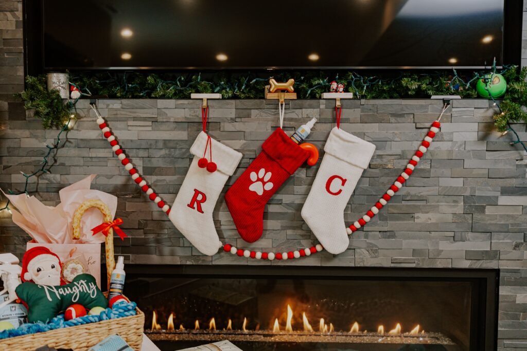 Christmas stocking filled with small gifts hanging on a mantel.