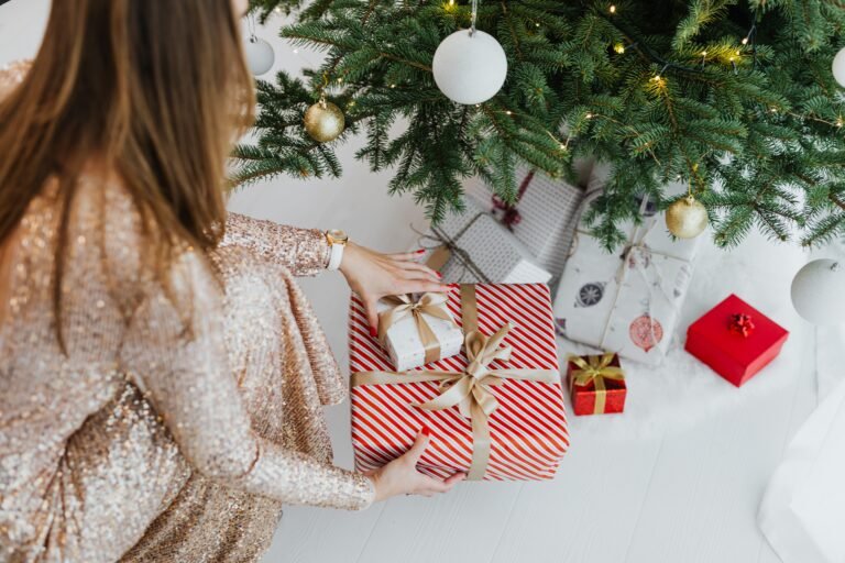 Christmas gift ideas under 25 dollars shown as wrapped gifts with gold ribbons