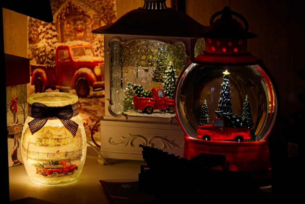 Glowing painted glass jar and red truck snow globe lanterns as Christmas table centerpieces